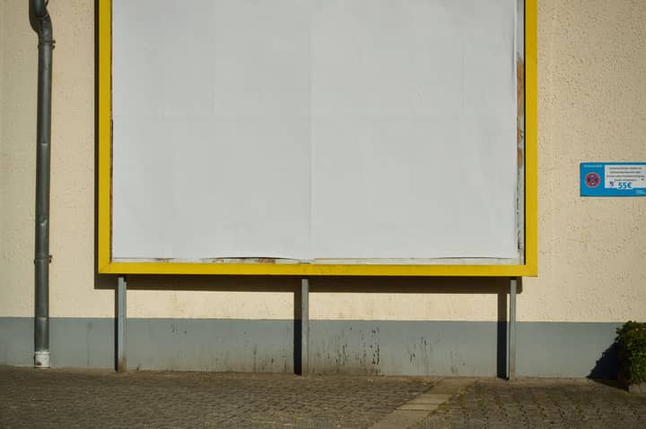 Empty billboard on a street with yellow frame, perfect for advertisement mockup.