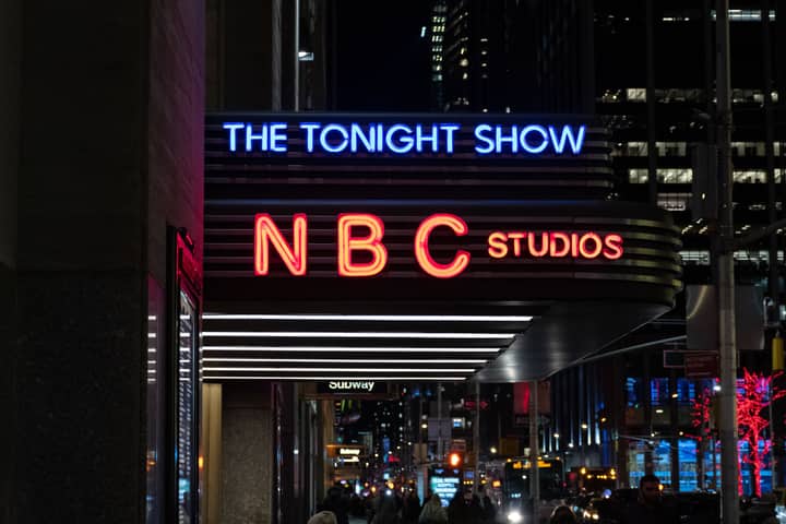 Vibrant neon signs illuminate NBC Studios in New York City, capturing vibrant night life.