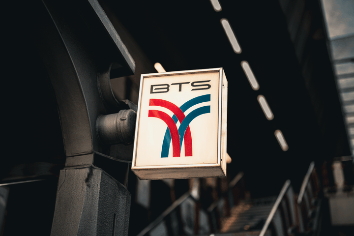 Close-up of the iconic BTS Skytrain sign at a station in Bangkok, Thailand.