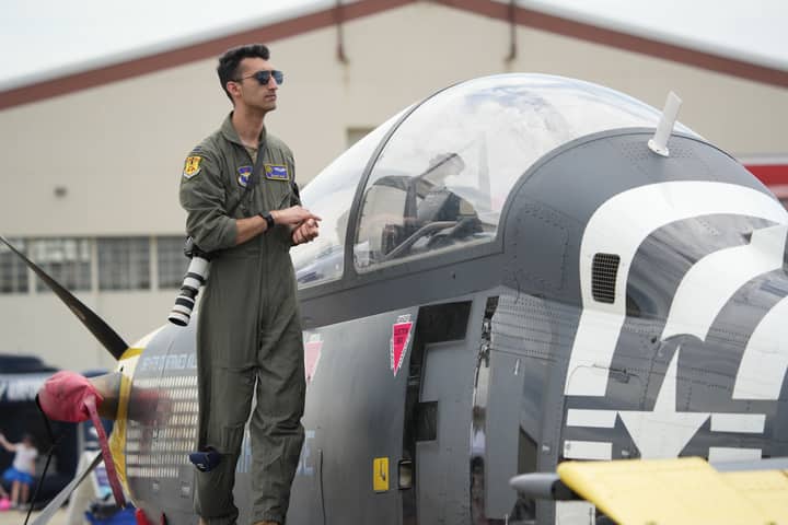 A military pilot standing on a fighter jet during an air show in Hampton, Virginia.