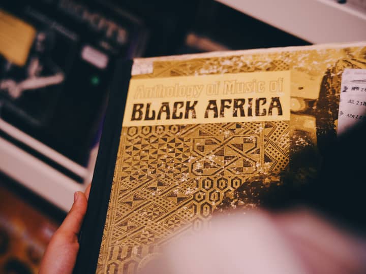 Vintage album cover titled 'Anthology of Music of Black Africa,' held by a hand, showcasing intricate designs.