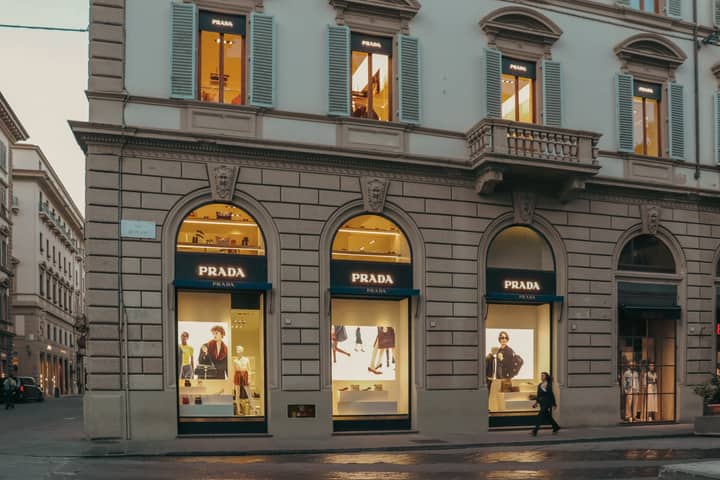 A stylish view of a Prada store facade in Florence, Italy, during evening hours.