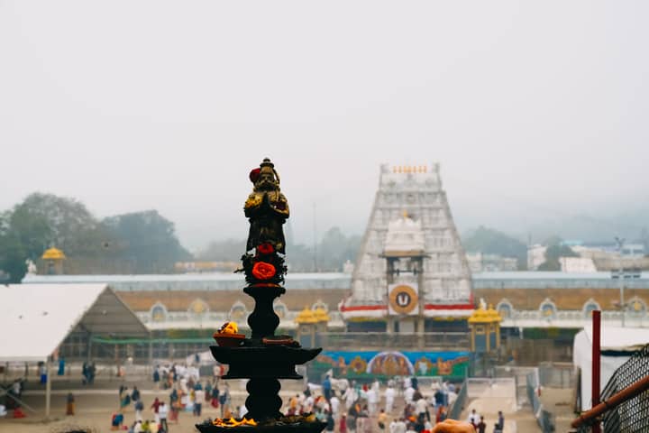 View of Tirupati Temple with a traditional oil lamp in the foreground, capturing the essence of Indian spirituality.