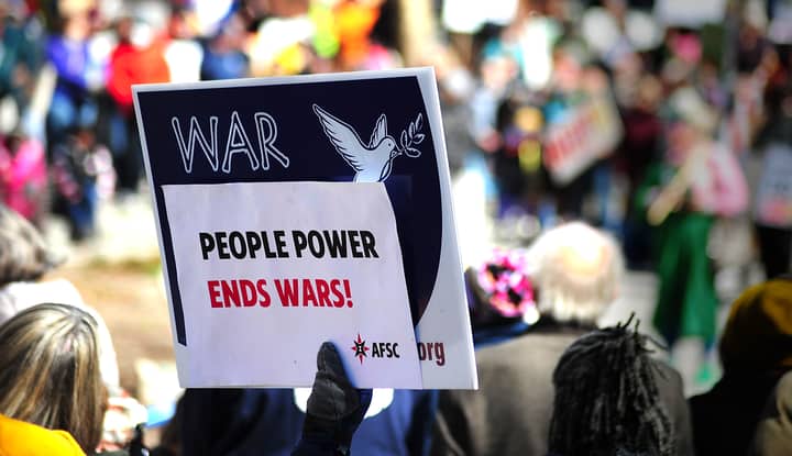 Protest sign reading 'People Power Ends Wars!' at a rally in Baltimore.