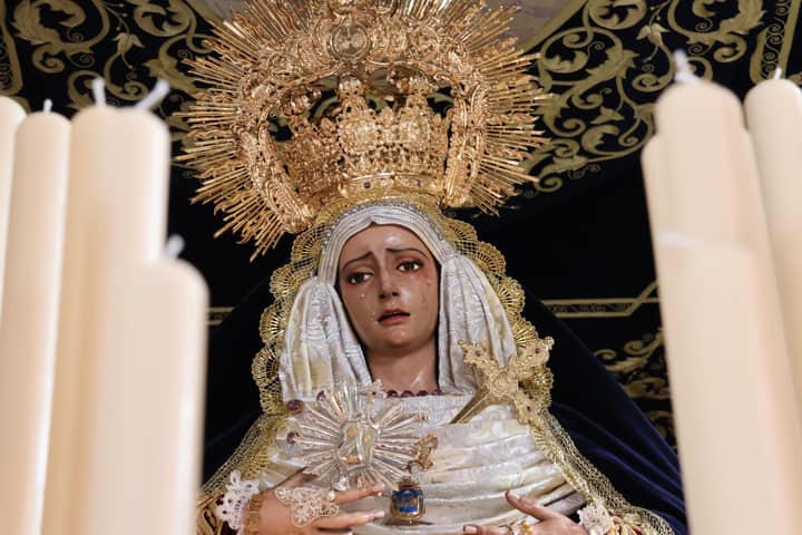 Detailed view of a Madonna statue adorned with candles during Semana Santa in San Fernando.