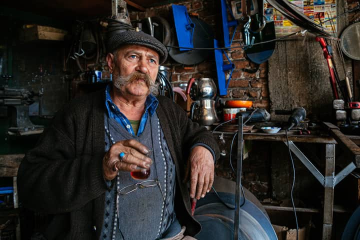 Artisan enjoying tea in a traditional Denizli workshop, displaying Turkish culture.