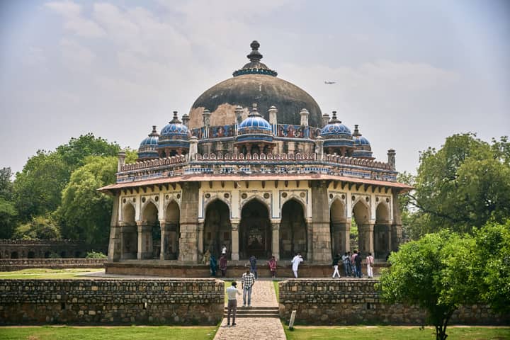 The majestic Isa Khan's Tomb stands amidst lush greenery in Delhi, showcasing Mughal architecture.