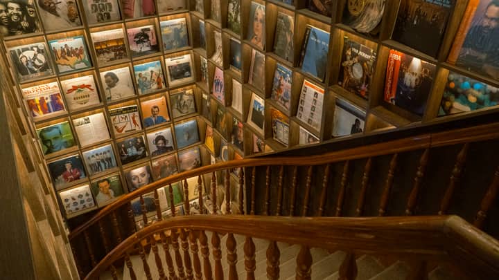 Staircase lined with vintage record albums on display, creating a nostalgic atmosphere.