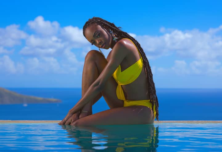 Woman relaxing by the infinity pool with ocean view in Saint Kitts.