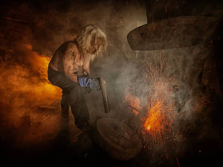A blacksmith in Cimahi, Indonesia, crafts metal amidst fiery sparks, showcasing traditional craftsmanship.