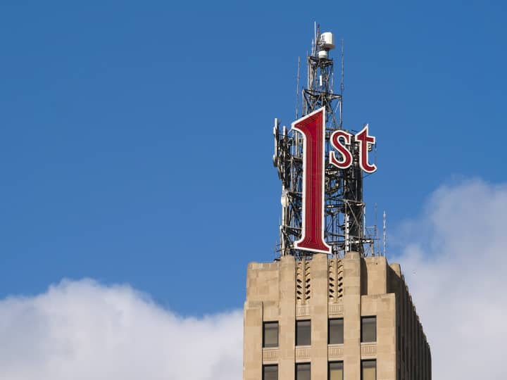 Close-up of the '1st' sign on a historic building in St. Paul, Minnesota, with a clear blue sky.