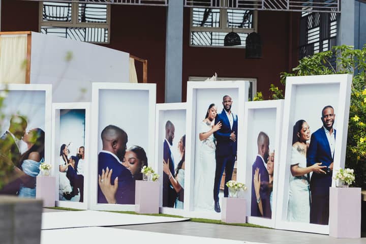 Large portrait displays at an African outdoor wedding showcasing a couple's special moments.