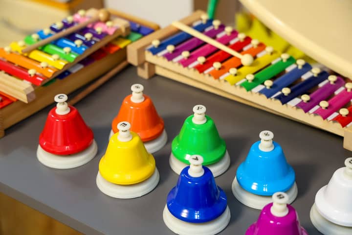 Vibrant xylophones and hand bells arranged on a table, ideal for music education themes.