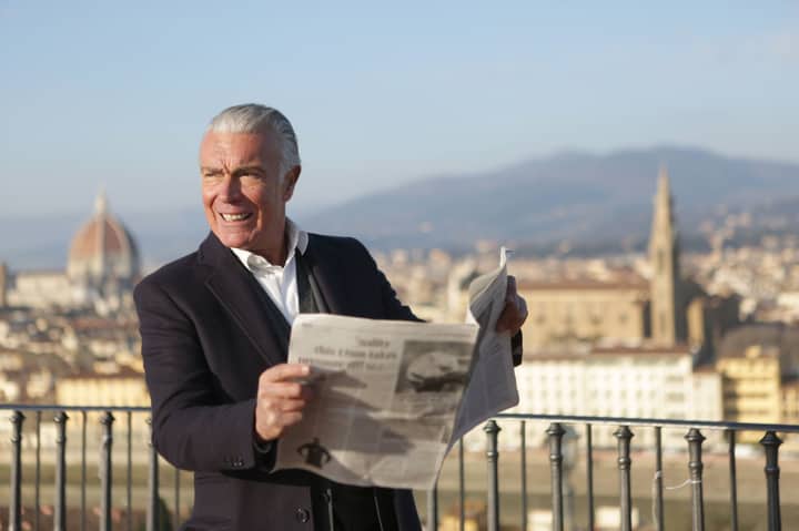 Elderly man enjoying newspaper on Florence's scenic overlook with the Duomo view.