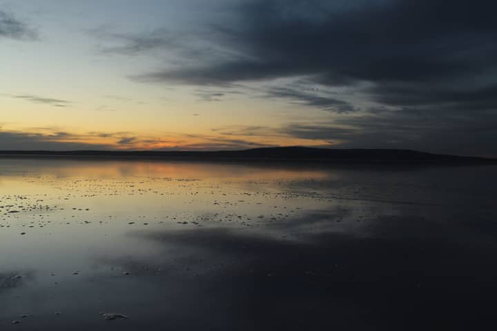 A tranquil sunset reflection on a vast salt lake in Türkiye, capturing calm and natural beauty.