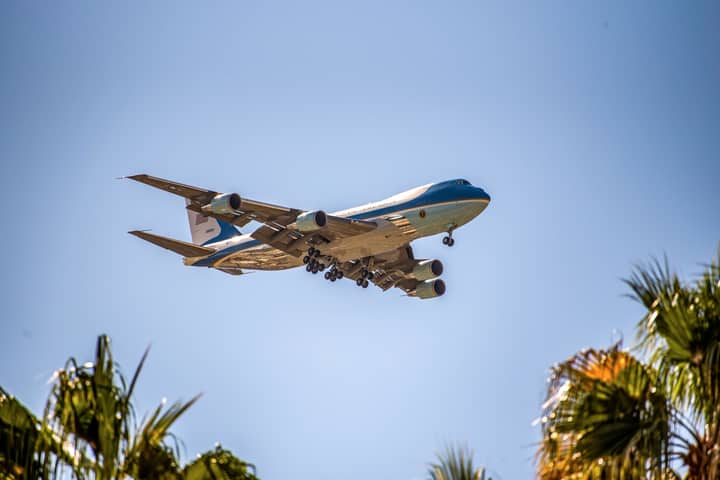 Presidential aircraft Air Force One flying above palm trees in Palm Springs, California.