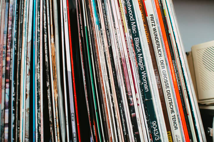 Stack of classic vinyl records neatly arranged on a shelf indoors.