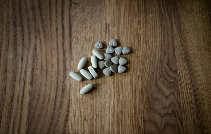 From above of set of different assorted medical pills arranged on lumber surface