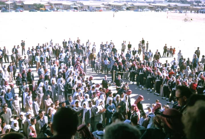 A large crowd gathers outdoors under sunny conditions in Saudi Arabia.