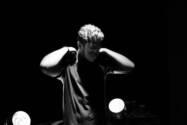 Intriguing portrait of a masked man in spotlight. Artistic and mysterious.