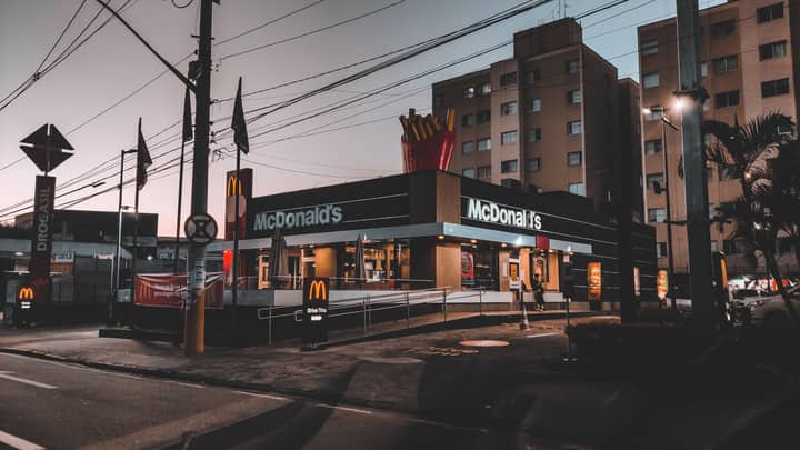 Exterior of modern residential buildings located in suburb near road with signboards and banners and fast food restaurant