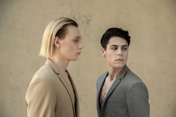 Stylish young men in formal suits posing for a fashion portrait.