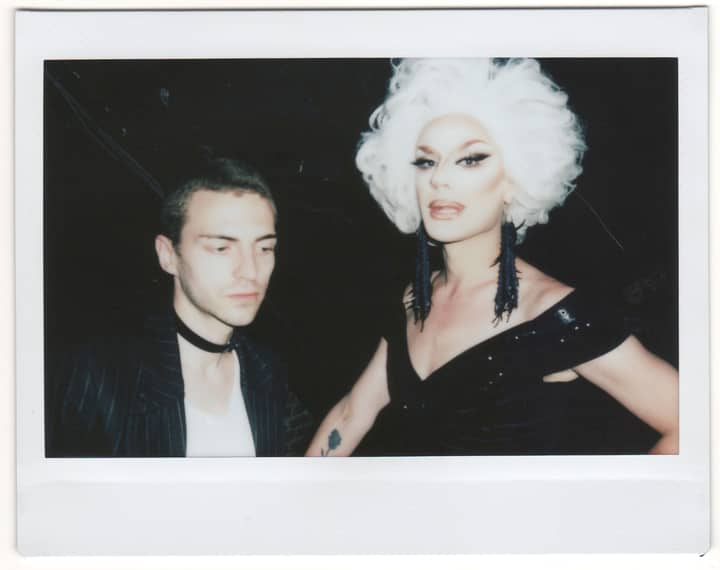 Vintage polaroid photo of a drag queen and a person at a nightclub party.