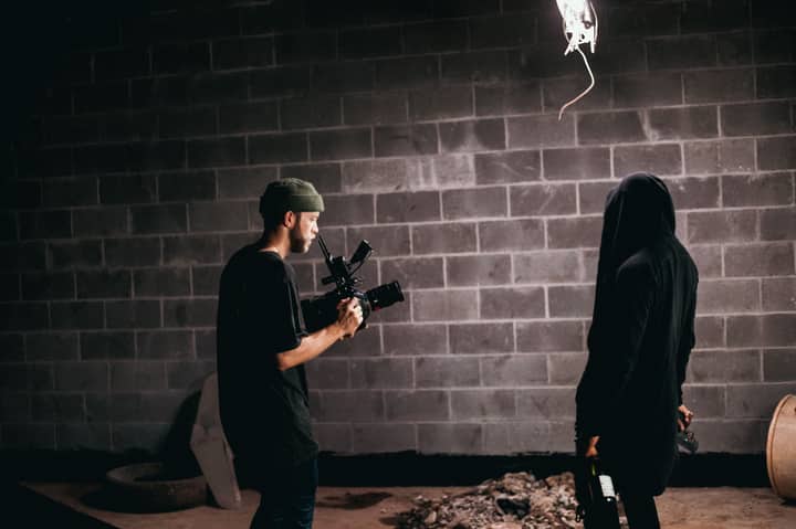 Photographer capturing candid moments on an indie film set with a handheld camera.