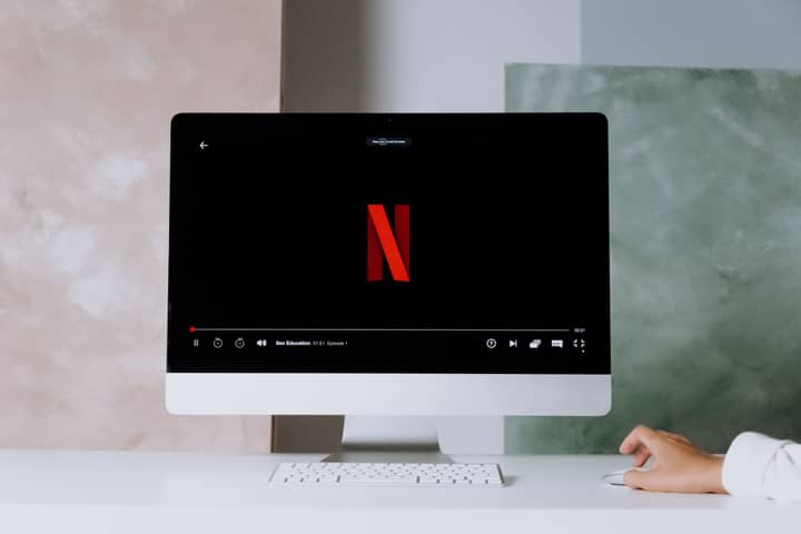 A minimalist workspace scene featuring a desktop displaying a streaming service, ideal for modern lifestyle themes.