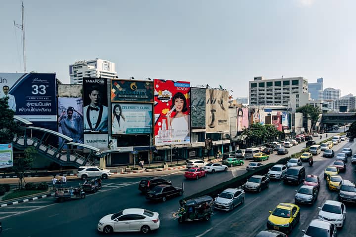Dynamic cityscape of Bangkok showcasing heavy traffic and colorful billboards in the metropolis.