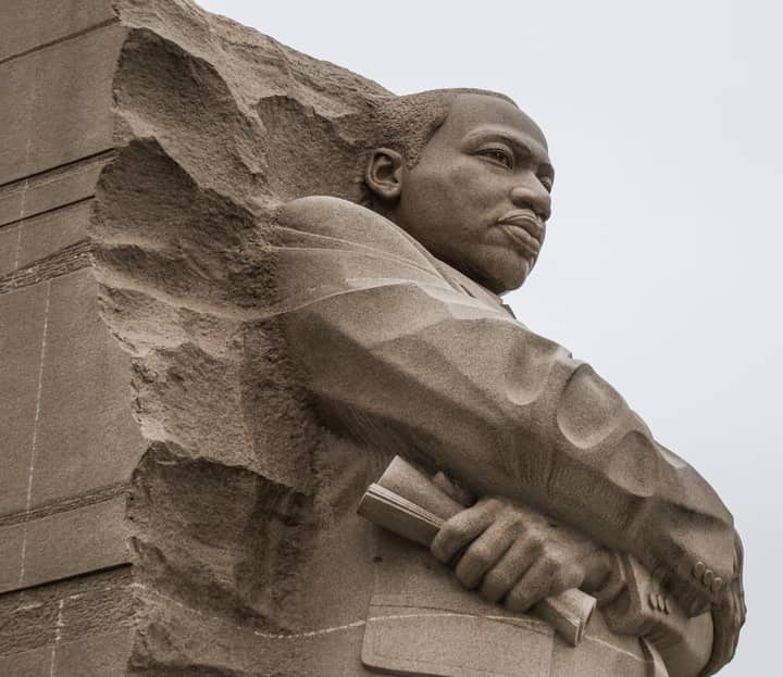 Low angle of granite statue of public right fighter located in memorial center on cloudy day