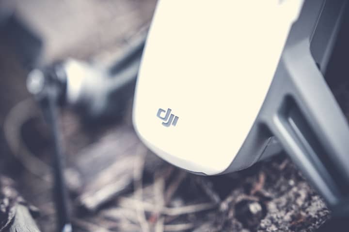 Detailed shot of a drone's body resting on outdoor ground, showcasing technology.