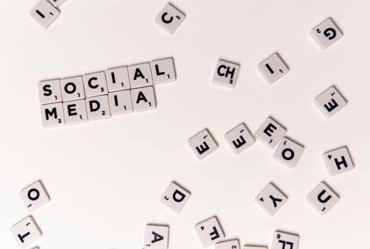Scrabble tiles spelling 'Social Media' on a white background, symbolizing digital communication.