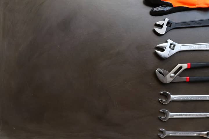 Assorted wrenches on a dark background with space for text. Ideal for industrial and tool-related design.