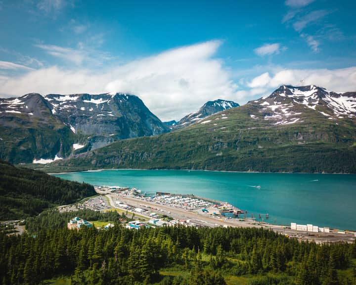 Scenic aerial view of a fjord surrounded by snow-capped mountains in Alaska, USA.