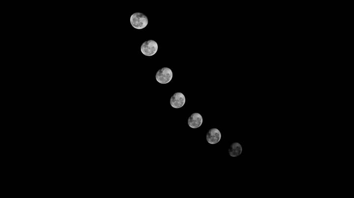 Black and white photo showing the phases of the moon against a dark night sky, creating a celestial scene.