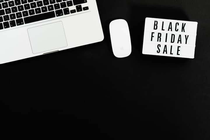 Black Friday sale sign with a laptop and mouse on a black background. Perfect for online shopping promotions.