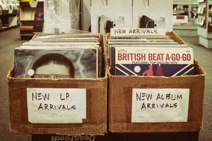 Explore a vintage record store with boxes of new LP and album arrivals.