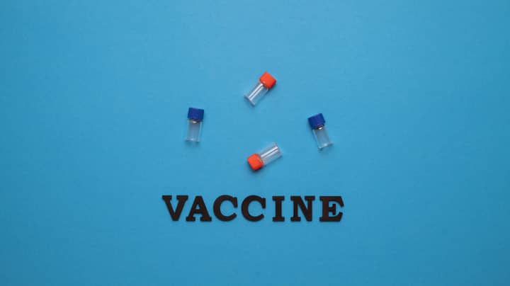 Three small vials and the word 'VACCINE' on a blue background, representing vaccination and health.