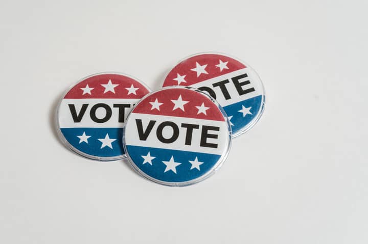 Red, white, and blue voting badges promoting elections on a clean white background.