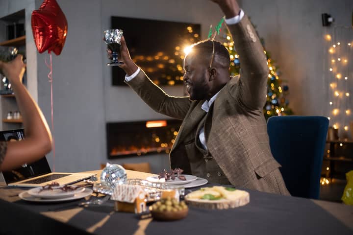 Joyful Christmas party with friends celebrating indoors. Warm, festive vibes.