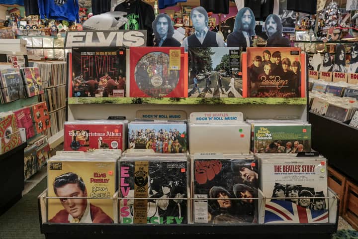 Retro vinyl collection featuring The Beatles and Elvis Presley in a classic music shop.