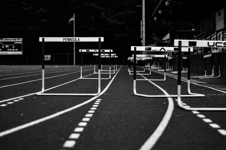 Monochrome image of hurdles on an empty sports track, perfect for athletic themes.
