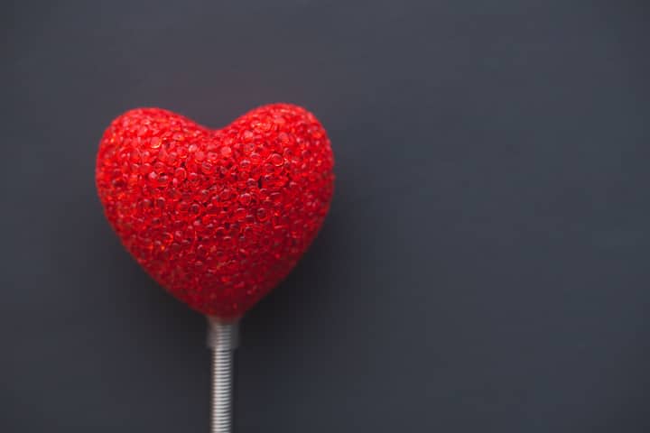 A vibrant red heart on a dark backdrop, symbolizing love and romance.