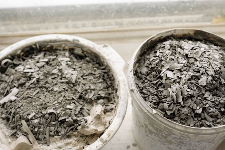 Two buckets filled with ash and debris, possibly from construction or cleanup.