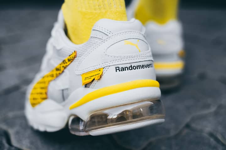 White and yellow Puma sneakers featuring unique design elements, perfect for fashion enthusiasts.