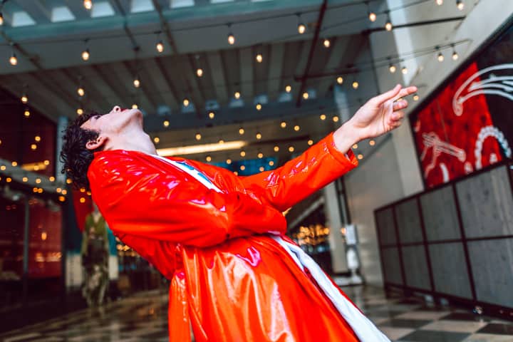 A vibrant dance performance shot indoors with dramatic lighting and color.