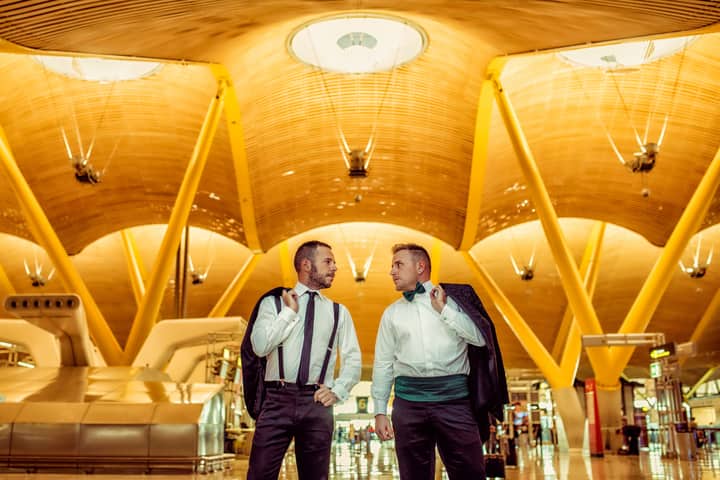 Two men in formal attire engage at the stunning Madrid-Barajas Airport.