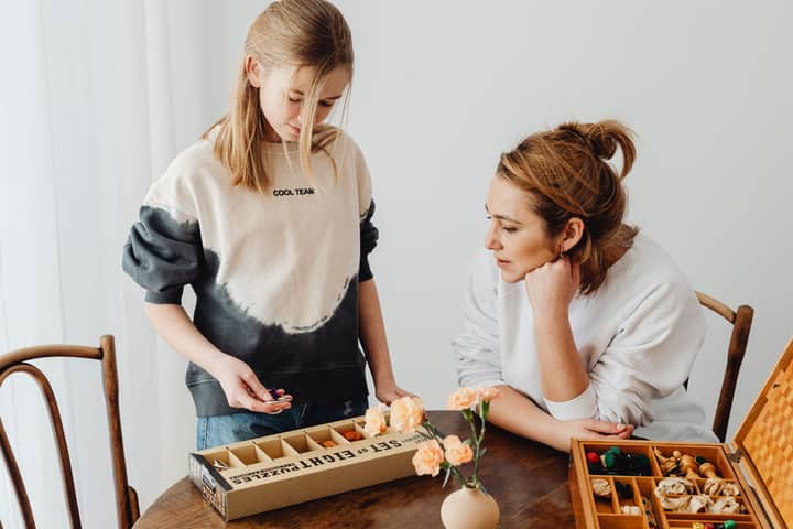 A mother and daughter engaged in puzzle-solving, enhancing creativity and bonding indoors.
