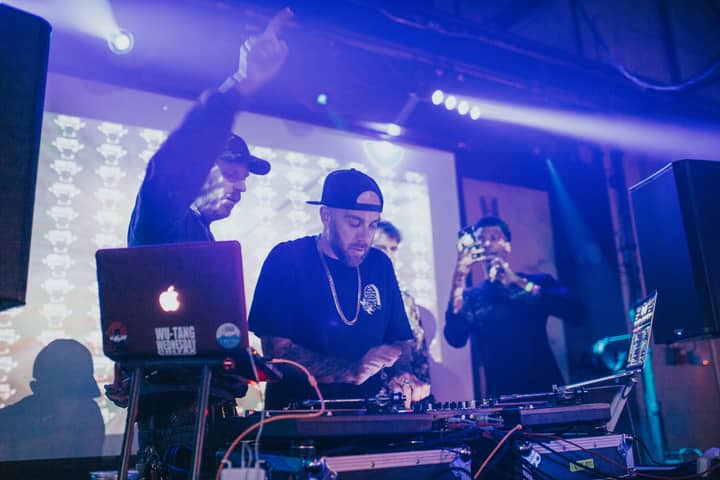 Energetic DJ spinning tracks at a live event in Denver nightclub with colorful stage lights.